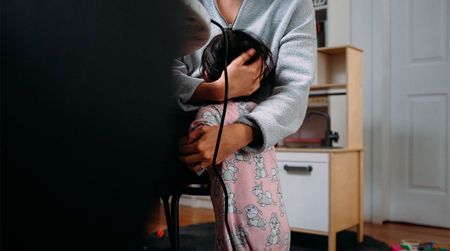 mãe abraçando filho no home office