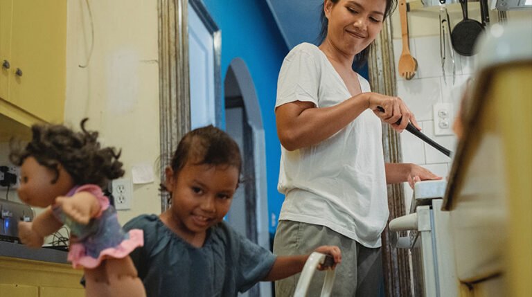 criança brincando perto de sua mãe enquanto cozinha