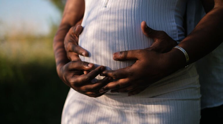 Homem e grávida tocando a barriga dela