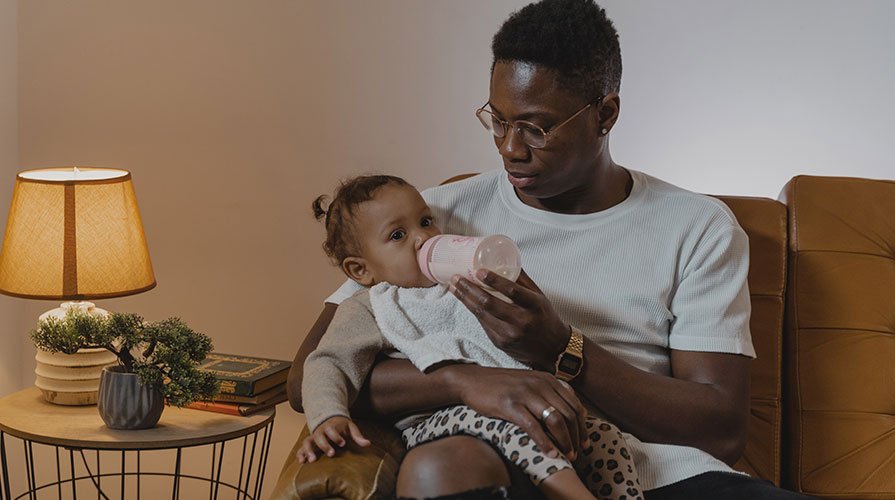 pai dando mamadeira para filha
